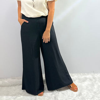 Womens black wide leg trouser pants with an elastic waistband featuring a relaxed fit and flowy silhouette for a sleek, comfortable look.