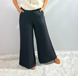 Womens black wide leg trouser pants with an elastic waistband featuring a relaxed fit and flowy silhouette for a sleek, comfortable look.