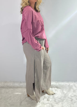 Gray oversized linen pants with wide legs, side slit panels, large front patch pockets and an elastic waistband