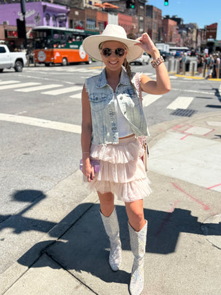 Womens sleeveless denim vest with raw hem and sparkling rhinestone embellishments, Perfect piece for concerts and downtown Nash.