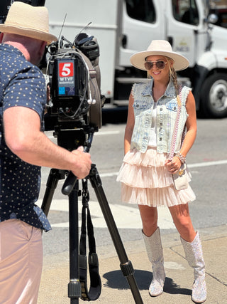 Womens sleeveless denim vest with raw hem and sparkling rhinestone embellishments, Perfect piece for concerts and downtown Nash.