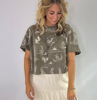 Women's Rust and Sage western graphic cropped tee with cowboy boots, hats, horseshoe and cactus print