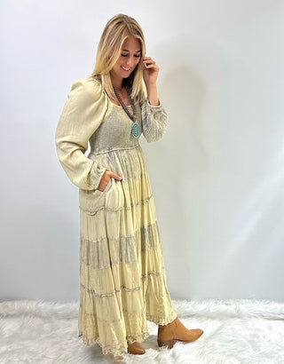 Women's long tiered boho dress with smocked bodice, long cuffed sleeves and flowing layered skirt, styled for a relaxed feminine look