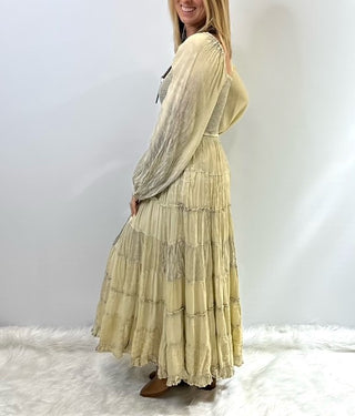 Women's long tiered boho dress with smocked bodice, long cuffed sleeves and flowing layered skirt, styled for a relaxed feminine look