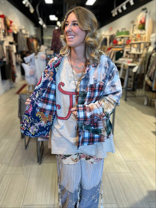 Handcrafted reversible patchwork flannel jacket with quilt inspired panels in blue, red, and earth tones with zigzag stitching, inside features a paisley pattern