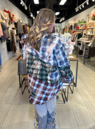 Handcrafted reversible patchwork flannel jacket with quilt inspired panels in blue, red, and earth tones with zigzag stitching, inside features a paisley pattern