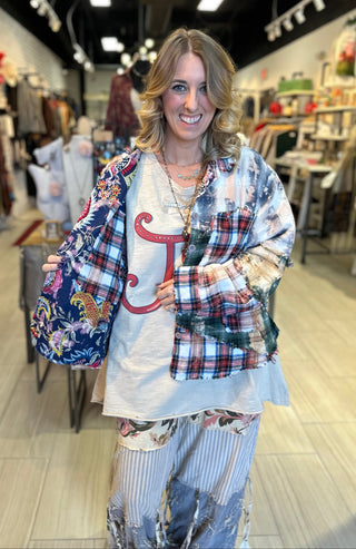 Handcrafted reversible patchwork flannel jacket with quilt inspired panels in blue, red, and earth tones with zigzag stitching, inside features a paisley pattern