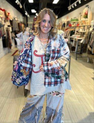 Handcrafted reversible patchwork flannel jacket with quilt inspired panels in blue, red, and earth tones with zigzag stitching, inside features a paisley pattern