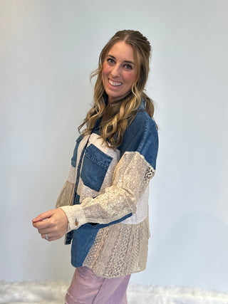 Mixed media denim shirt with lace patchwork, button-up front, long sleeves, and relaxed boho shirt-jacket fit.