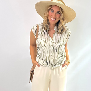 The Olive Wave Top features a button front light weigh blouse in a cream and olive green texture wave pattern, perfect for transitional summer days. Dress it up or throw over a swimsuit