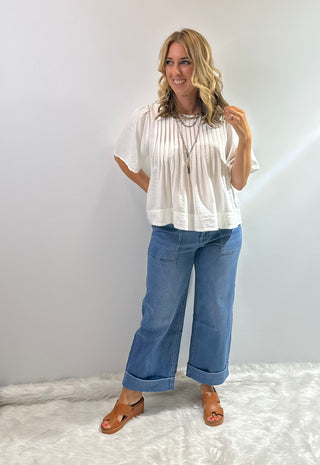 Womens white short sleeve peplum blouse with pin tuck detailing on the bodice with a flared hem