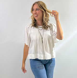 Womens white short sleeve peplum blouse with pin tuck detailing on the bodice with a flared hem