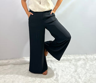 Womens black wide leg trouser pants with an elastic waistband featuring a relaxed fit and flowy silhouette for a sleek, comfortable look. 