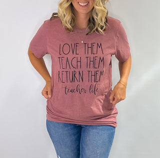 Mauve pink graphic t shirt with the phrase love them, teach them, return them. Teacher Life in black bold lettering