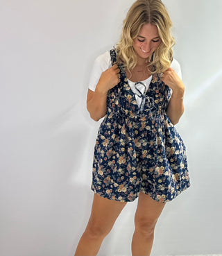 Denim short romper with floral print, v neckline and front pleated detail for a feminine, structured fit. 