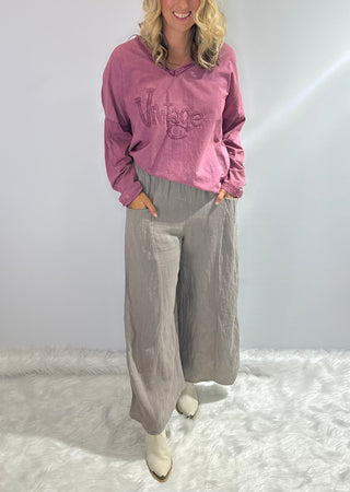 Gray oversized linen pants with wide legs, side slit panels, large front patch pockets and an elastic waistband