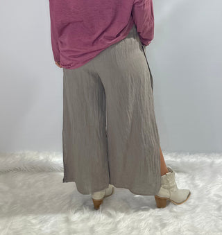 Gray oversized linen pants with wide legs, side slit panels, large front patch pockets and an elastic waistband