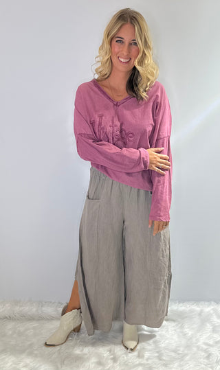 Gray oversized linen pants with wide legs, side slit panels, large front patch pockets and an elastic waistband
