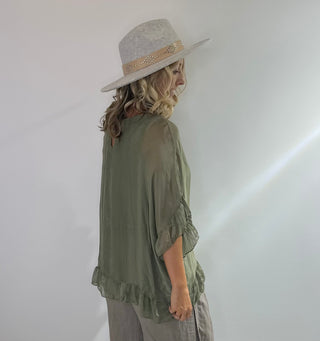 Sage Green oversized silk blouse with ruffle short sleeves, ruffle hem, and back keyhole button closure