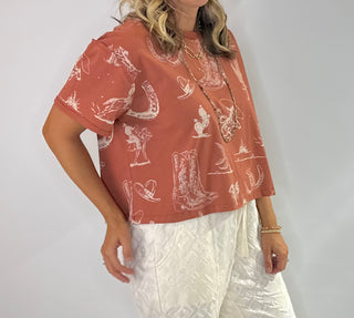 Women's Rust and Sage western graphic cropped tee with cowboy boots, hats, horseshoe and cactus print