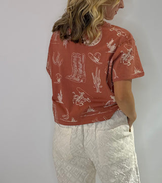 Women's Rust and Sage western graphic cropped tee with cowboy boots, hats, horseshoe and cactus print