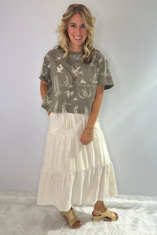 Cream Embroidered tiered maxi skirt with pockets, featuring delicate stitching and a flowy layered silhouette.