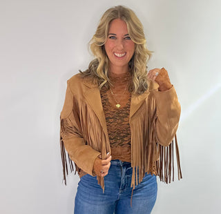 Stylish camel-colored suede jacket with long sleeves, a classic collar, and fringe detailing along the hem and sleeves. Perfect for adding a boho chic touch to any outfit