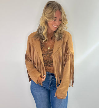 Stylish camel-colored suede jacket with long sleeves, a classic collar, and fringe detailing along the hem and sleeves. Perfect for adding a boho chic touch to any outfit