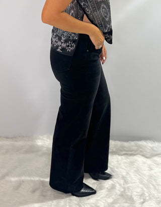 Black stretch denim jeans with waist stitching detail, straight leg, full length, and relaxed fit. 