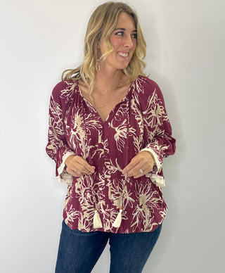 Floral printed 3/4 sleeve top with V-neck tassel tie, flutter lace trim sleeves, and flutter hem in olive/cream or burgundy/cream