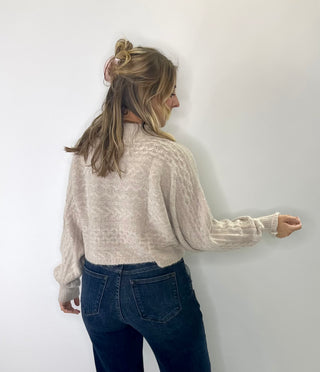 Brushed Marled cable knit cropped mock neck sweater with cozy texture and soft neutral tones. 
