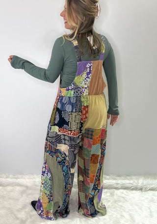 Soft multi-color patchwork jumpsuit featuring mixed fabrics in gentle tones and relaxed wide-leg silhouette
