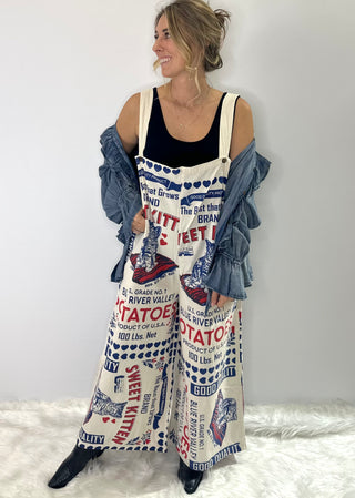 Beige Cotton Jumpsuit with vintage blue and red Kitten brand graphics, adjustable straps and back pockets. 