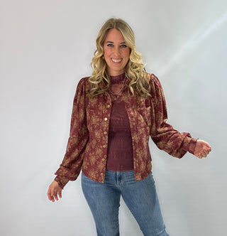 Burgundy knit top with gold floral pattern, vintage snap buttons, puff sleeves, and collar