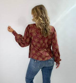 Burgundy knit top with gold floral pattern, vintage snap buttons, puff sleeves, and collar