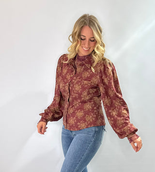 Burgundy knit top with gold floral pattern, vintage snap buttons, puff sleeves, and collar