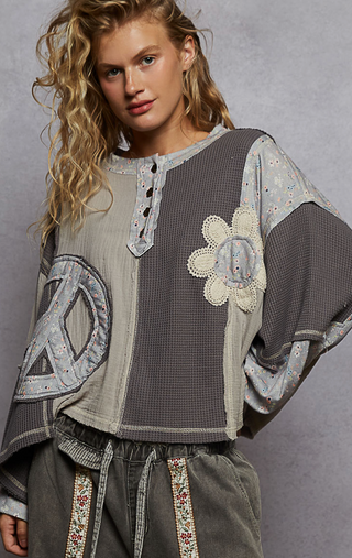 Gray French Terry Knit Oversized top with round neck balloon sleeves, ribbed cuffs and oversized peace sign floral patch with a button detail by Pol