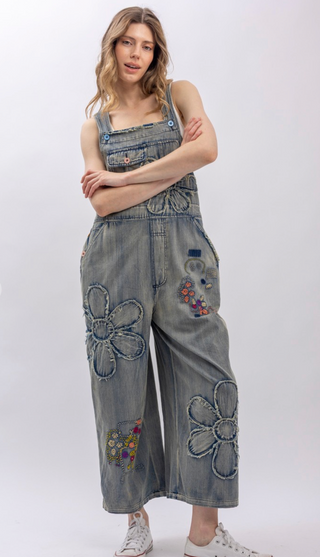 Flower Patchwork And Embroidered Denim Overalls with full length silhouette, adjustable button shoulder straps, side button closures, and functional bib pockets
