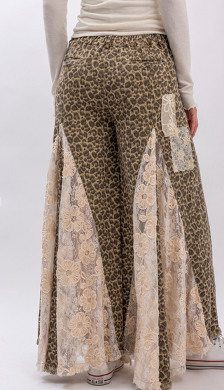 Taupe leopard print wide leg pants with lace and ruffle detailing, elastic waistband, full length exaggerated silhouette and side pockets