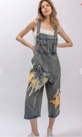 Mineral wash patchwork denim bib overalls with wide leg silhouette, adjustable shoulder straps, midi length, bib pocket and side pockets