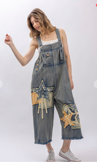 Mineral wash patchwork denim bib overalls with wide leg silhouette, adjustable shoulder straps, midi length, bib pocket and side pockets