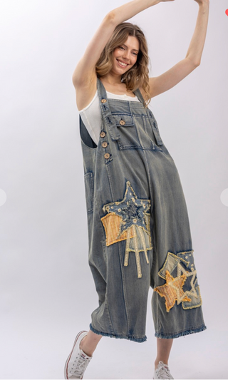 Mineral wash patchwork denim bib overalls with wide leg silhouette, adjustable shoulder straps, midi length, bib pocket and side pockets
