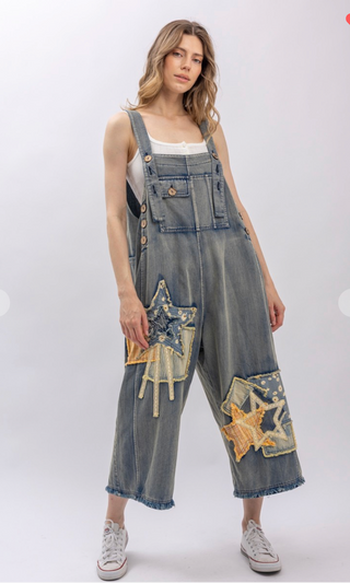 Mineral wash patchwork denim bib overalls with wide leg silhouette, adjustable shoulder straps, midi length, bib pocket and side pockets