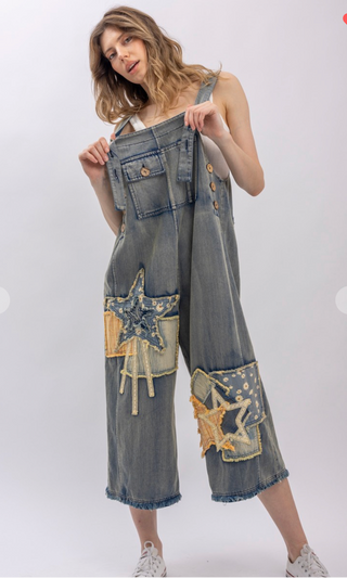 Mineral wash patchwork denim bib overalls with wide leg silhouette, adjustable shoulder straps, midi length, bib pocket and side pockets