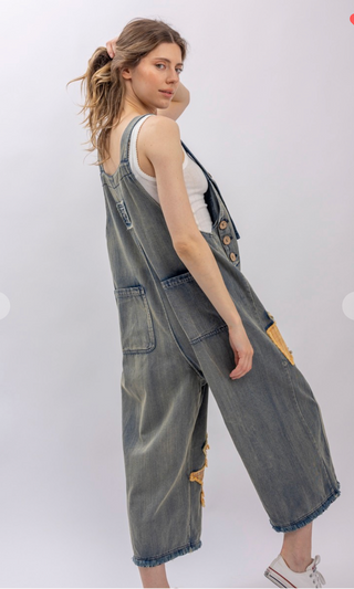 Mineral wash patchwork denim bib overalls with wide leg silhouette, adjustable shoulder straps, midi length, bib pocket and side pockets