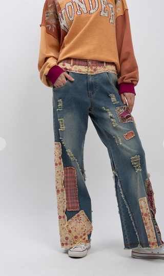 Distressed patchwork stretch denim pants with elastic waistband, loose fit, full-length silhouette and five pocket style