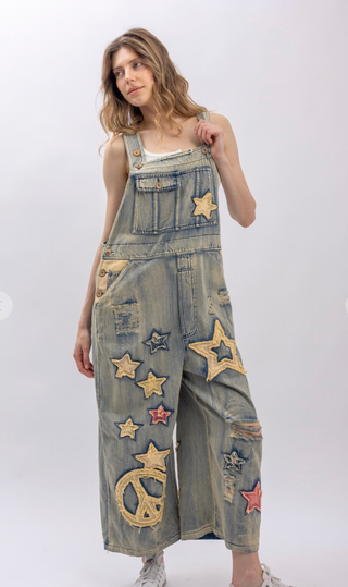 Star and Peace Patchwork denim bib overalls with oversized fit, adjustable button straps, side button closures, front bib pocket and full length silhouette