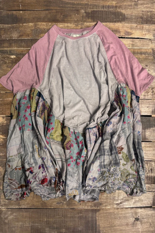 Raglan sleeve shirt with floral fabric draped over it on a wooden surface