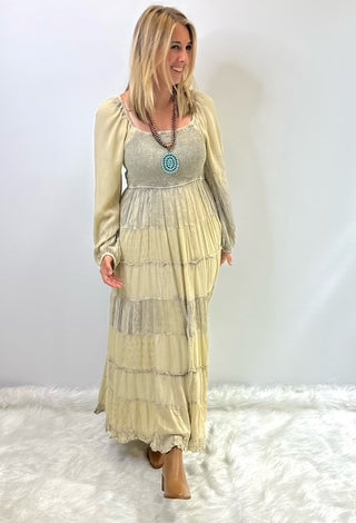 Women's long tiered boho dress with smocked bodice, long cuffed sleeves and flowing layered skirt, styled for a relaxed feminine look