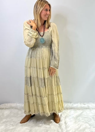 Women's long tiered boho dress with smocked bodice, long cuffed sleeves and flowing layered skirt, styled for a relaxed feminine look